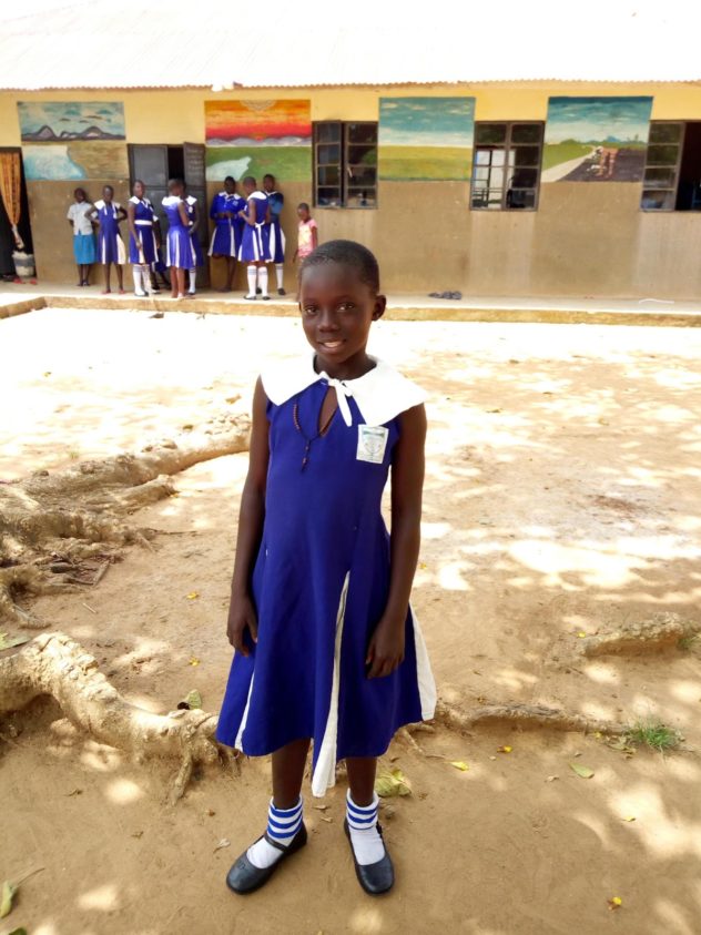 Patience standing in front of a school building